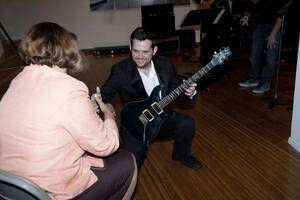 Photograph  19 of Dan Bukvich with Navin Chettri and the Jazz Choir I's Musical Performance 'The Village Sings and Drums and Dances, an evening of engaged voices and rhythms.' Dan Bukvich is Professor of Music. Navin Chettri is Bukvich's student. Pictured: Performer from Jazz Choir I with audience member, University of Idaho Prichard Gallery.