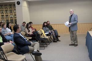 Photograph  1 of Robert Caisley, Marco Deyasi, and Lauren 'Lojo' Simon's Colloquium Panel Discussion 'Art about Art: Collaboration and Expression of Self and Other in Creating New Work for Theatre (on the play "Adoration of Dora").' Robert Caisley is Associate Professor of Theatre Arts and Head of Dramatic Writing. Marco Deyasi is Assistant Professor of Art and Design. Lauren 'Lojo' Simon is a graduate student. Pictured: Rodney Frey introduces Deyasi, Simon, and Caisley.
