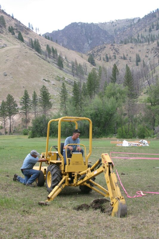 Jim Pope "tweaks" the engine while CNR student Craig Holmberg operates the backhoe.