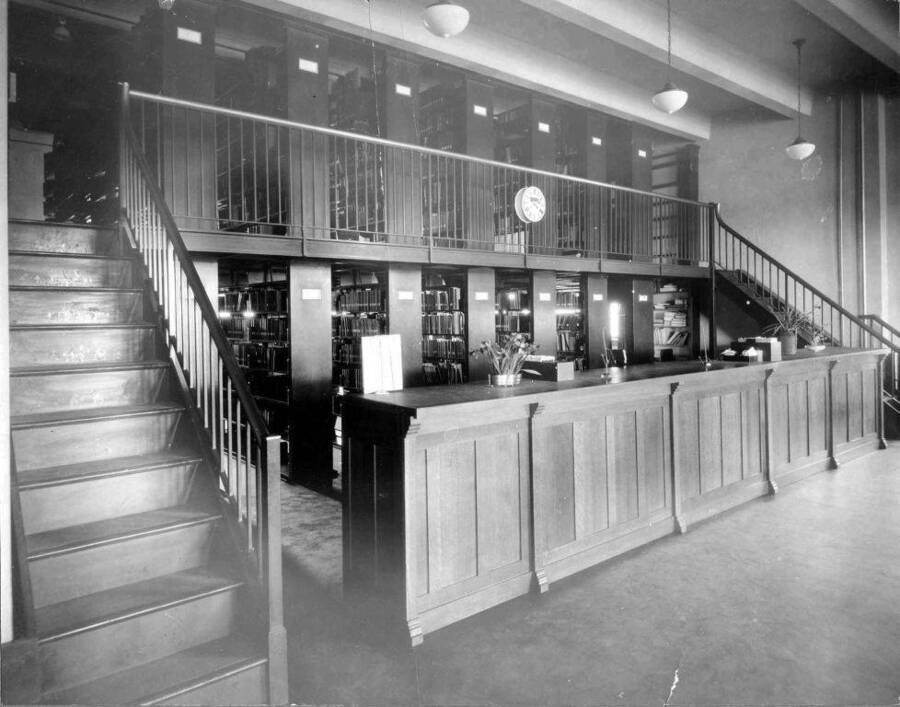 Interior view of the library which shows the circulation desk and staircase.
