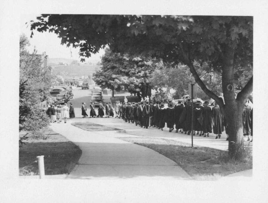Students walking down the street in an academic procession.