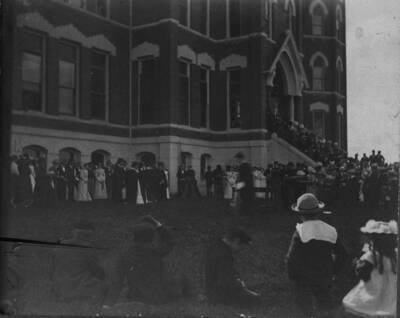 Graduates and families after graduation in front of the Administration Building.