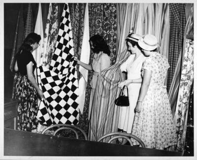 Students are examining material for a drapery class.