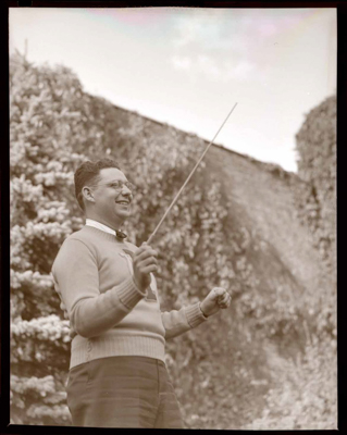 Band conductor wearing University of Idaho sweater and holding a baton.