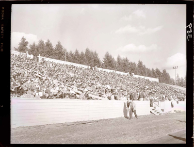 Marching band and cheerleaders performing on football field.