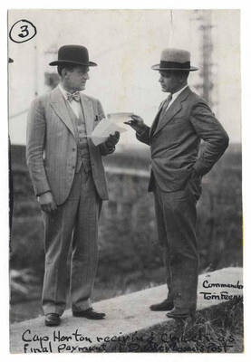 Captain Horton receiving payment from Commander Tom Feeny for construction of Memorial Gymnasium.