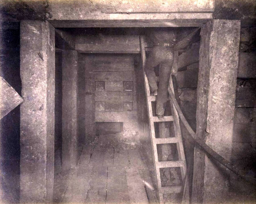 High ore 400 ft. level West Showing bulkheading in 1st floor and miner ascending to 2nd floor with hose for drilling machine