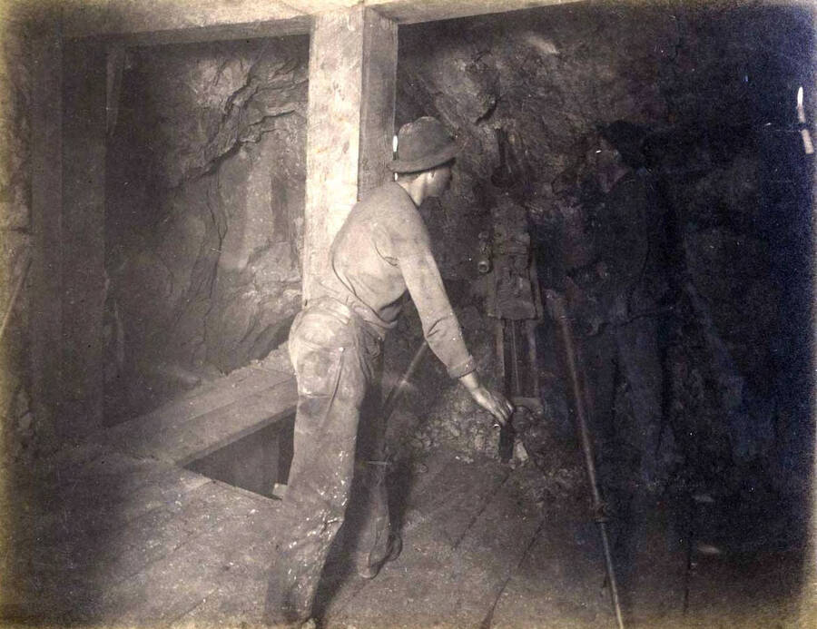 High ore 300 ft. level East Showing men and drilling machine on fourth floor drilling air on breast