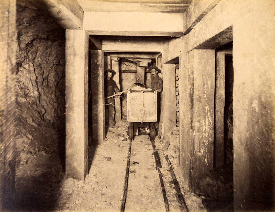 Mt Con 100 level East sill floor.  Showing miners in ore breast filling ore cars. Ore 12 ft.