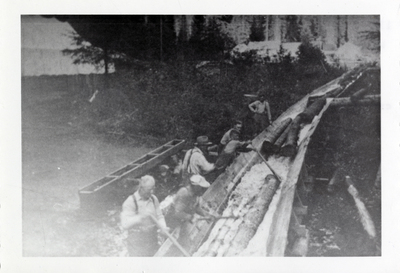 Water flowing and logs being separated in the Falls Creek flume. Feeder flume under construction on left. Credit Dick Reed.