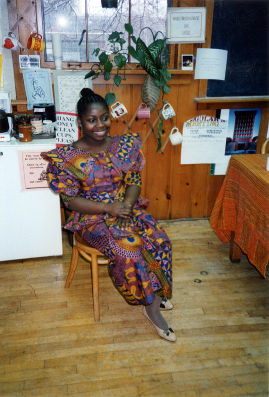 Harriet Essiam sitting in a wooden chair in the Women's Center.