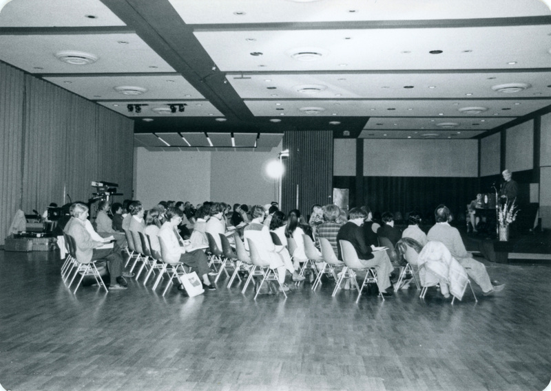 A side view of the audience at a speaking event.