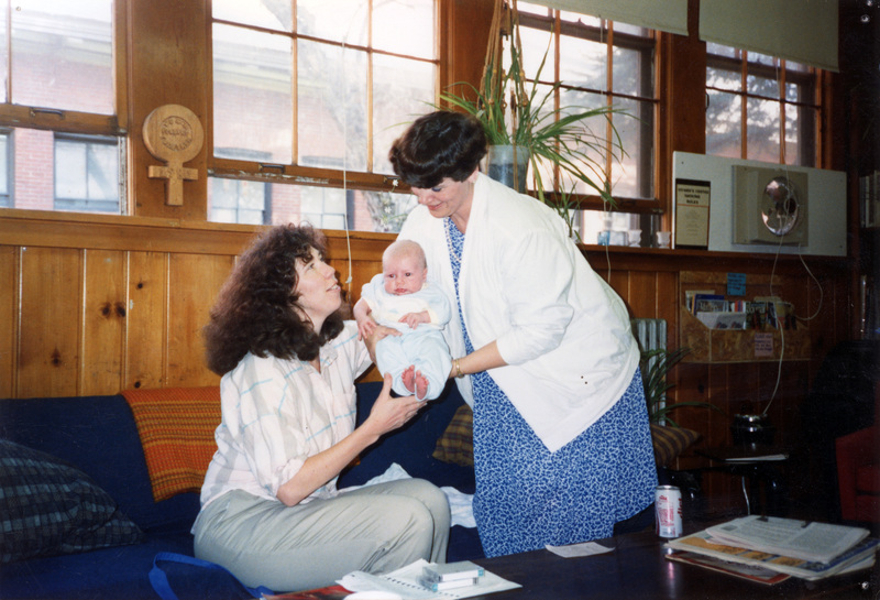 Two women holding a baby in the Women's Center.