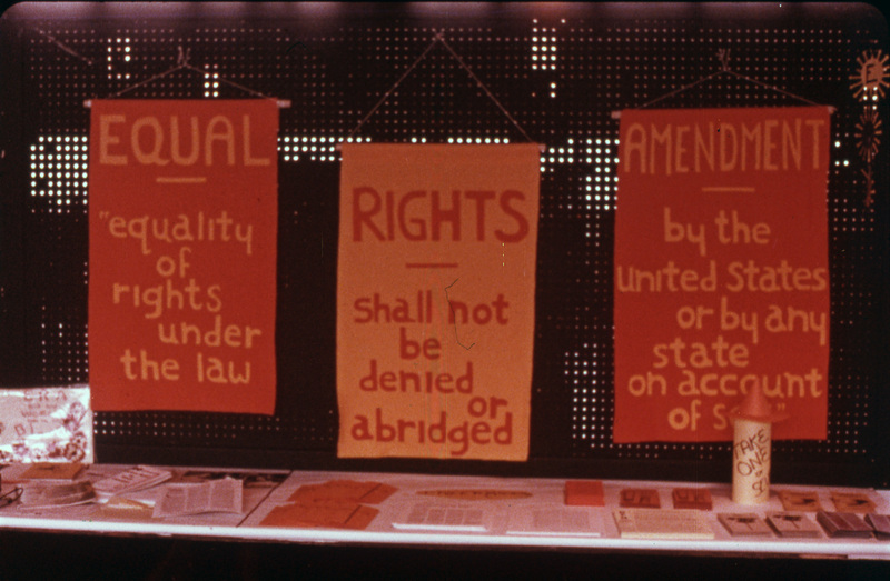 Three signs reading "Equal Rights Amendment: equality of rights under the law shall not be denied or abridged by the United States or by any state on account of sex."