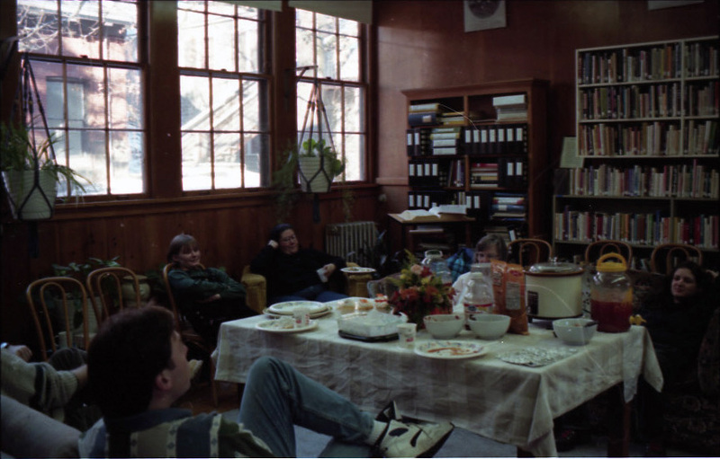 People sitting around a table in the Women's Center during a celebration.