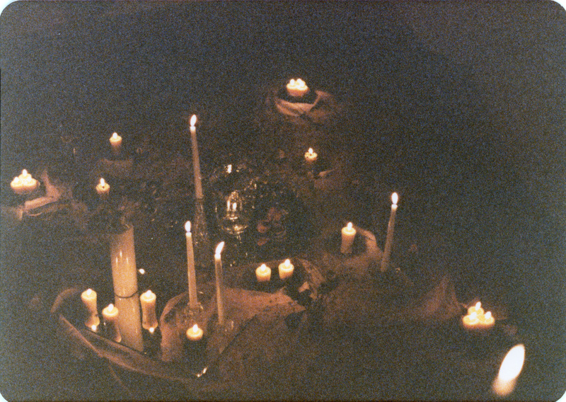 Photo from a recreation of Judy Chicago's The Dinner Party, held in St. Augie's. A shot of a table filled with lit candles of different sizes.