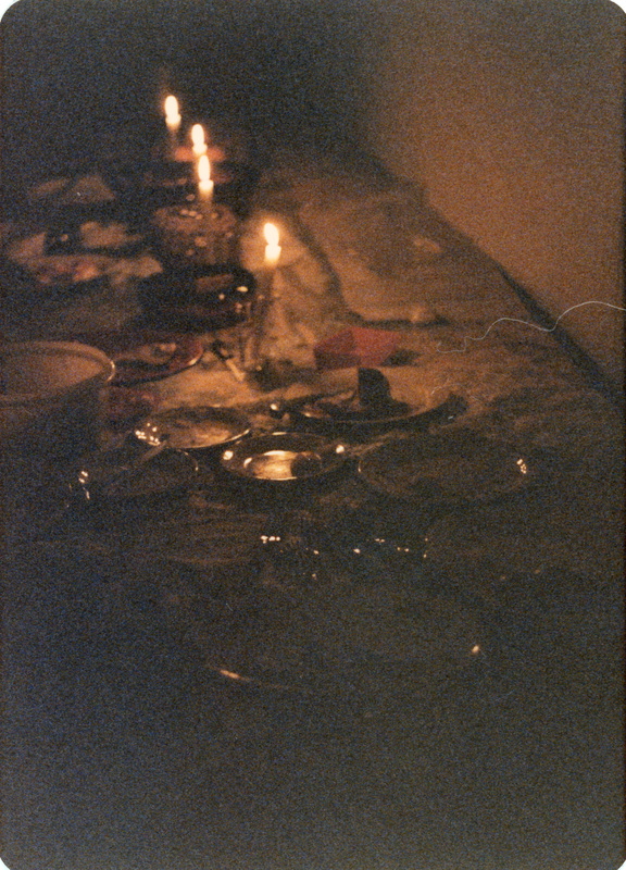 Photo from a recreation of Judy Chicago's The Dinner Party, held in St. Augie's. Dishes and lit candles on a table spread.