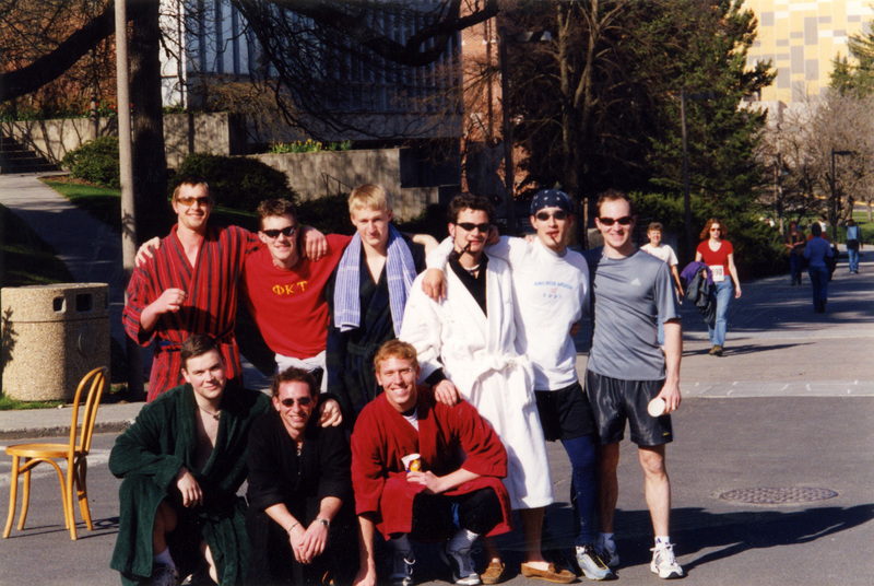 A group of men posing for the camera. Most are wearing bathrobes.