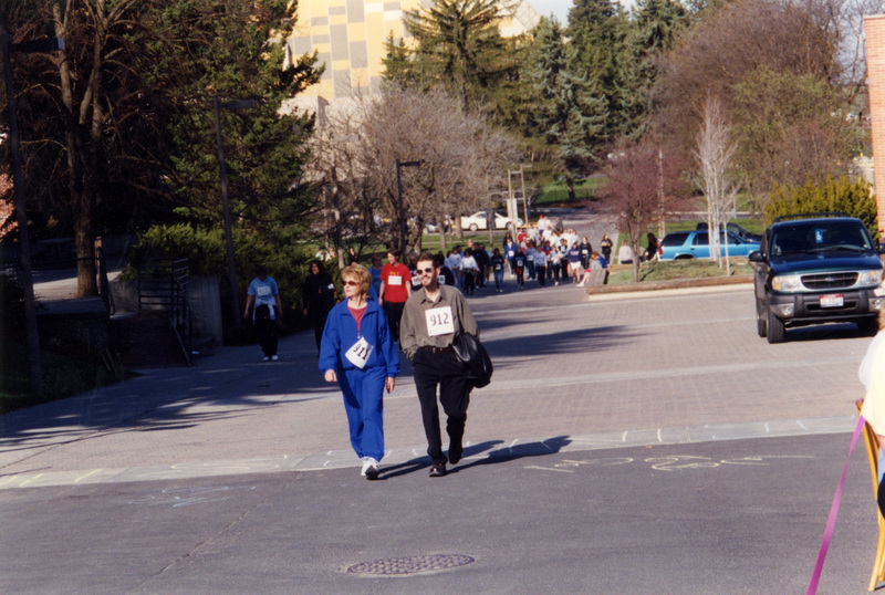A group of people wearing race numbers walking towards the camera.