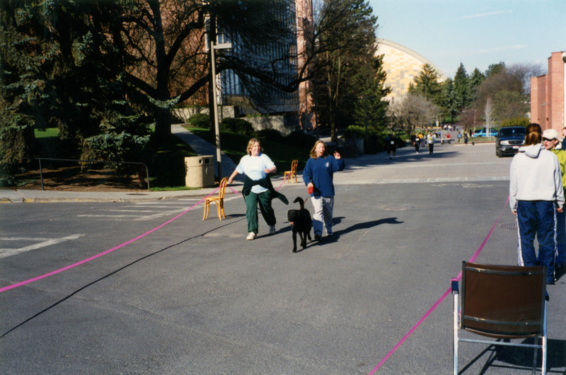 Two women and a dog walking towards the camera.