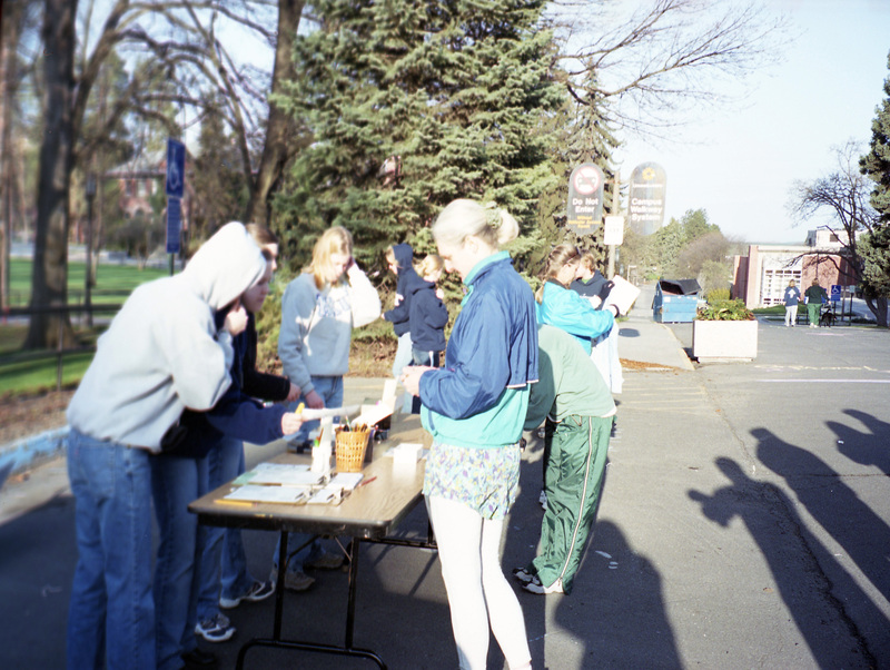 A group of people line up to receive race numbers.
