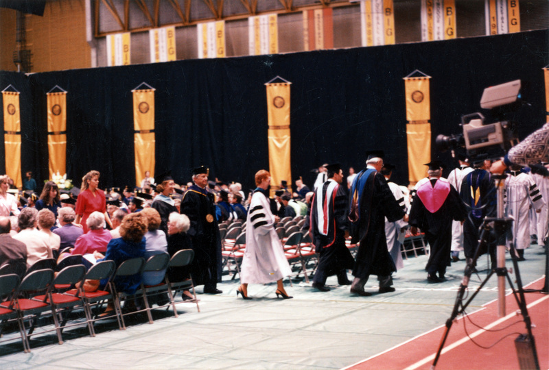 Scene during Elisabeth Zinser's inauguration. Zinser was the first female president of the University of Idaho. People in regalia walking away from the audience.