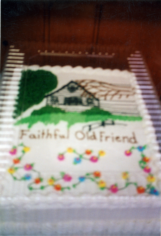 A photo of a cake which reads "Faithful Old Friend" and has an icing image of the Women's Center building on it.