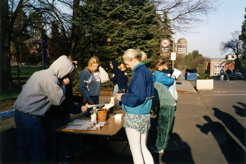 A group of people line up to receive race numbers. Jill Anderson is on the far right.