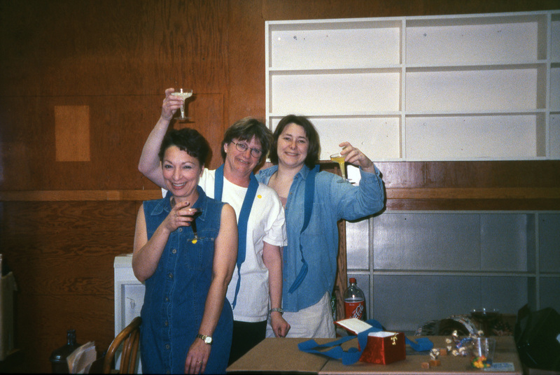 From left to right: Valerie Russo, Jill Anderson, and Chaucey Wittinger raising champagne glasses. Women's Center relocation from the Old Journalism Building to the Theatre Annex, Summer 2000.