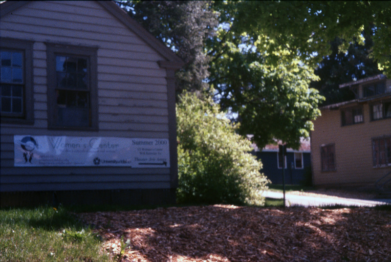 The outside of the Women's Center building. A white banner with text hangs on the side of the building. Women's Center relocation, Summer 2000.