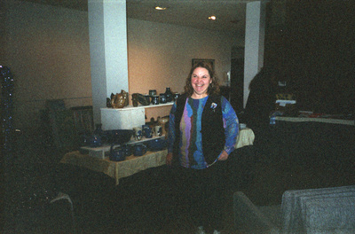 Jeanne Wood standing in front of pottery