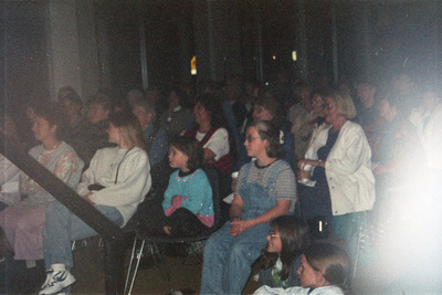 Children and adults sitting in an audience