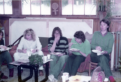 Five women sit and eat inside the Women's Center